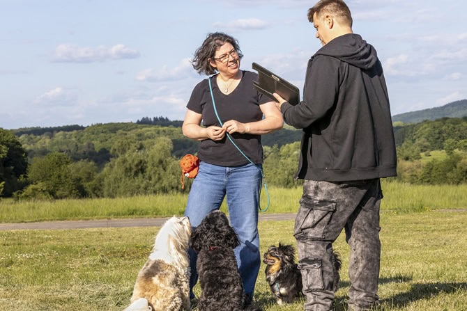 atn akademie hundetrainer ausbildung ab2 ATN Hundetrainer Ausbildung - Hundetrainer mit Kundin und Hunden auf der Wiese